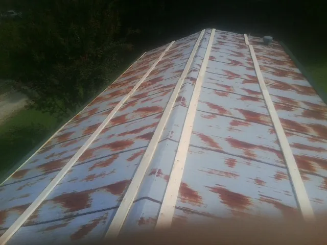 Rusted metal roof panels with new wood purlins before replacement — Storm Damage Roof Repair in Pine Brook by Roofing Brothers