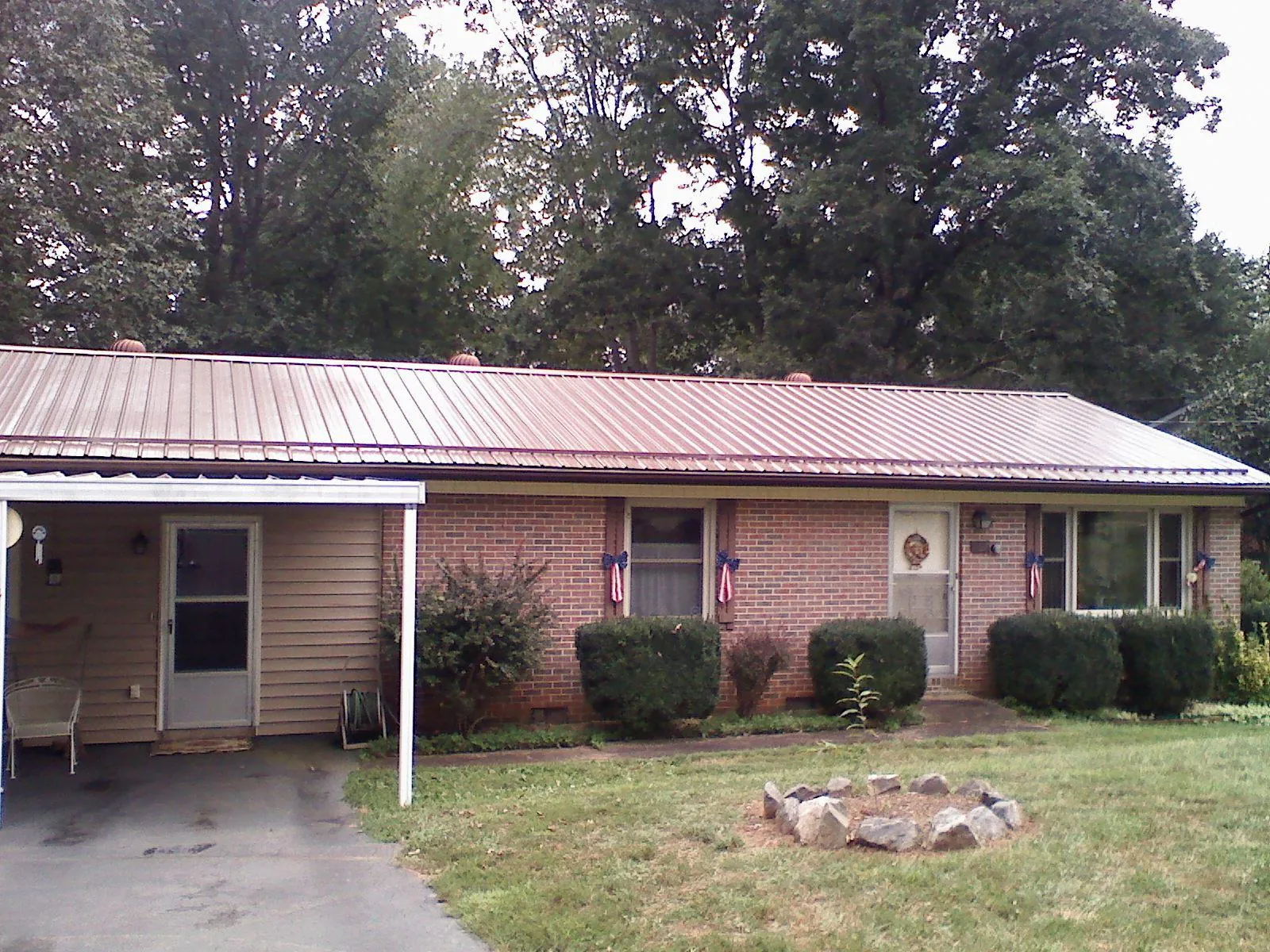 Bronze metal roof and carport on a brick ranch home — Roof Repair work by our crew in Pine Brook