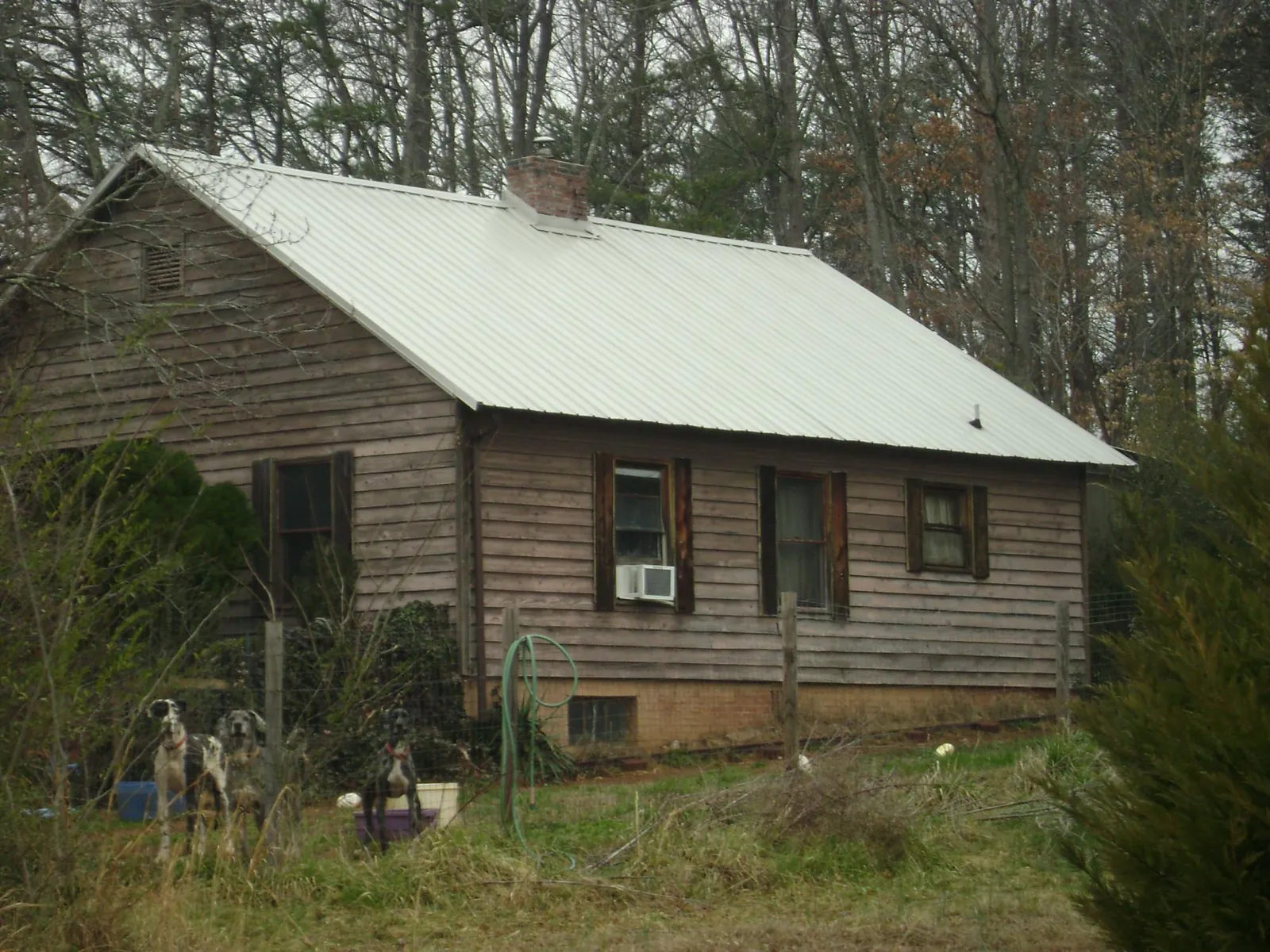 White metal roof on an old wood sided farmhouse, from a Metal Roof Installation job in Pine Brook